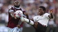 Pemain West Ham, Michail Antonio (kiri), berusaha mengontrol bola dan melewati pemain MU, Tyrell Malacia, dalam laga pekan ke-35 Premier League 2022/2023 yang berlangsung di London Stadium, Senin (8/5/2023) dini hari. (AP Photo/Ian Walton)