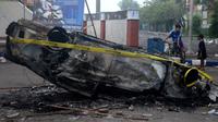 Mobil dibakar di luar Stadion Kanjuruhan, Malang, Jawa Timur, Minggu (2/10/2022). Sebanyak 127 orang tewas ketika para penggemar yang marah menyerbu lapangan sepak bola setelah pertandingan antara Arema FC dan Persebaya Surabaya pada 1 Oktober 2022. (PUTRI/AFP)