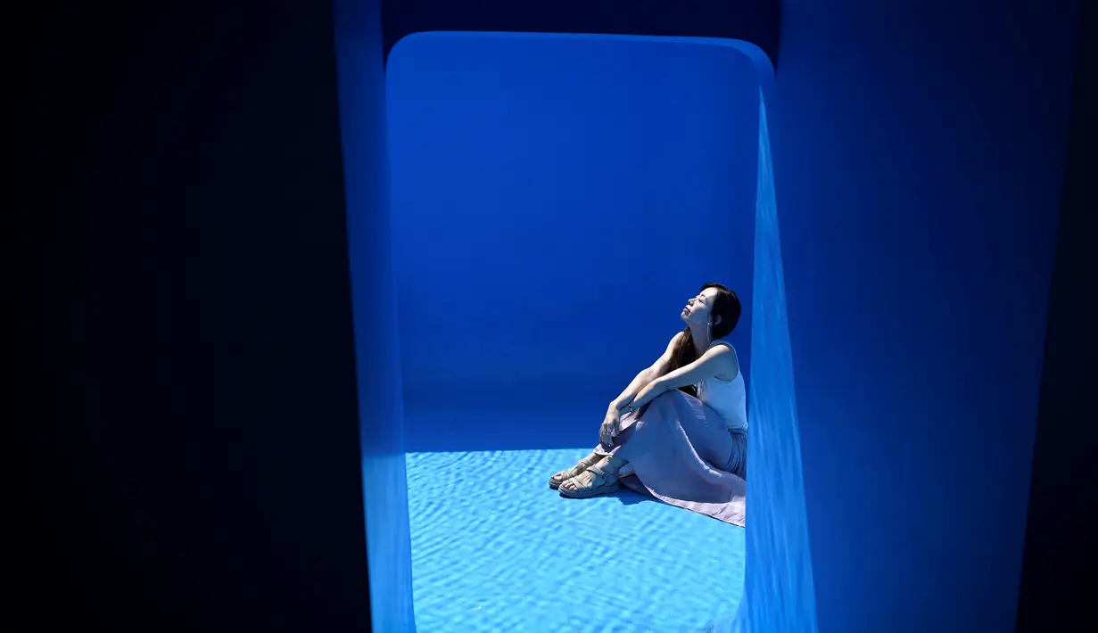 Seorang wanita berpose di karya seni Swimming Pool dalam sebuah pameran pameran bertajuk "The Confines of the Great Void" di Museum CAFA, Beijing, 23 Juli 2019. Karya seni unik itu pun banyak dikunjungi wisatawan yang ingin punya foto underwater keren tanpa harus basah-basahan. (WANG Zhao/AFP)