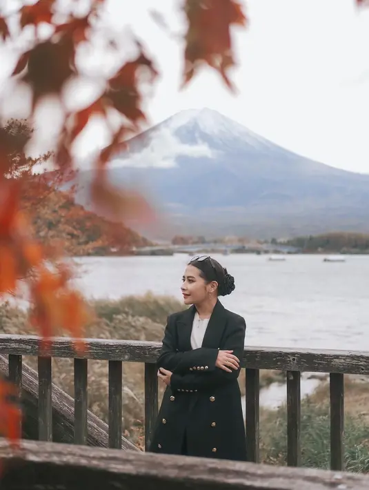 Ia mengenakan dalaman warna putih, ditumpuknya dengan long blazer hitam dengan banyak kancing emas. Penampilannya semakin manis dengan rok kotak-kotak dan midi boots hitam. [Foto: Instagram/prillylatuconsina96]