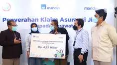Direktur AXA Mandiri Uke Giri Utama (kanan), disaksikan VP CSR Center Bank Mandiri Diwangkoro A. Ratam (kedua kanan), Ketua Umum DPP PPNI dr. Harif Fadillah (kiri) secara simbolis klaim untuk tenaga kesehatan yang gugur saat menangani COVID-19 di Jakarta, Kamis (26/8/2021). (Liputan6.com/HO/Alwi)