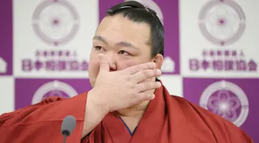 Pemegang predikat grand champion sumo, Kisenosato menyeka air matanya saat mengumumkan pensiun dari arena sumo dalam konferensi pers di Tokyo, Rabu (16/1). Kisenosato merupakan satu-satunya pesumo Jepang di liga teratas olahraga itu. (JIJI PRESS AFP)