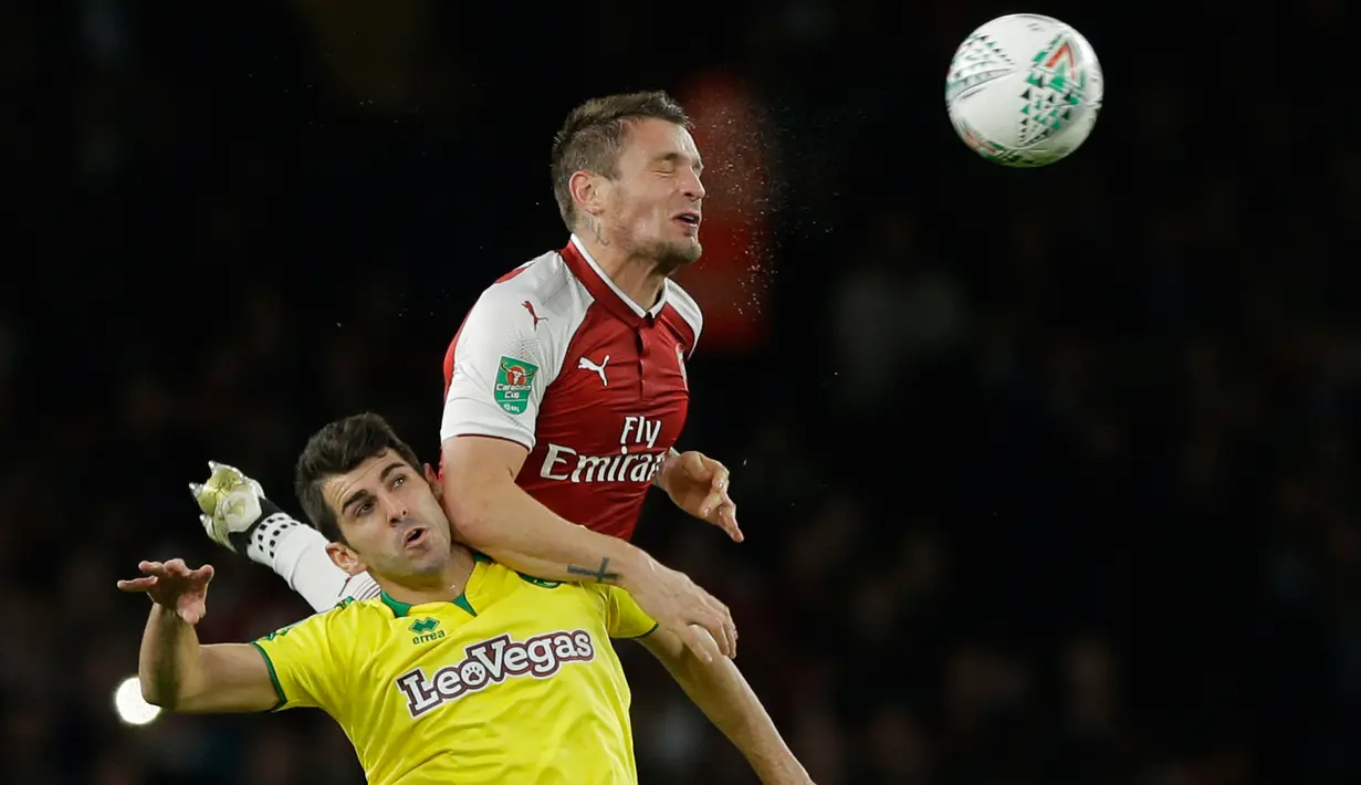 Pemain Arsenal, Mathieu Debuchy (atas) berebut bola dengan pemain Norwich City, Nelson Oliveira pada lanjutan Piala Liga Inggris di Emirates Stadium, Rabu (25/10). Edward Nketiah memborong gol Arsenal saat mengalahkan Norwich City 2-1. (AP/Alastair Grant)