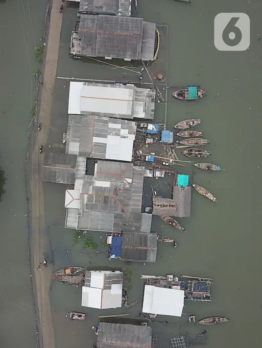 Foto udara banjir rob yang menggenangi rumah dan tambak warga di Desa Pantai Mekar, Muaragembong, Kabupaten Bekasi, Jawa Barat, Senin (6/12/2021). Banjir rob telah menggenangi wilayah tersebut selama empat hari akibat kenaikan permukaan air laut. (Liputan6.com/Herman Zakharia)