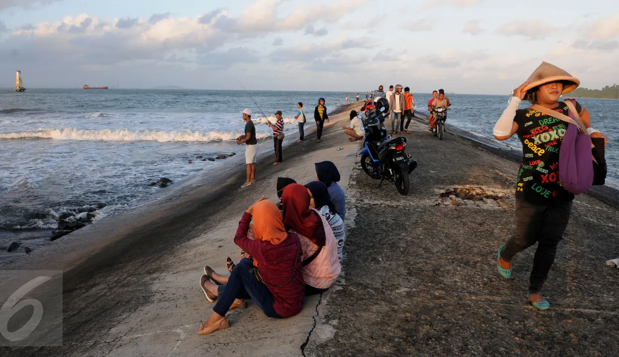  Sejumlah warga menikmati waktu senja saat matahari terbenam di Pantai Teluk Penyu Kabupaten Cilacap, Jawa Tengah,Jumat (29/7). Pantai Teluk Penyu merupakan salah satu tempat wisata andalan Kabupaten Cilacap, Jawa Tengah. (Liputan6.com/Helmi Afandi)