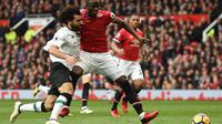 Winger Liverpool Mohamed Salah (kiri) berjibaku dengan bek Manchester United Eric Bailly pada laga di Old Trafford, Sabtu (10/3/2018). (AFP/Oli Scarff)