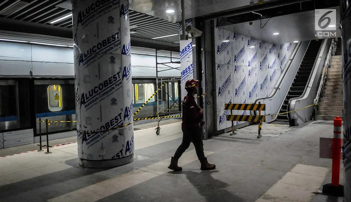 Pekerja berjalan dekat eskalator dan tangga Stasiun Mass Rapid Transit (MRT) Bundaran HI, Jakarta, Senin (10/12). (Liputan6.com/Faizal Fanani)