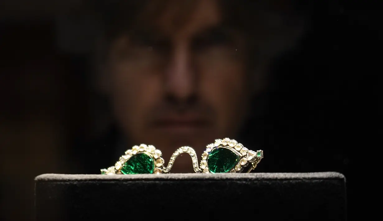 Seorang anggota staf melihat kacamata Mughal dengan lensa zamrud, dalam bingkai berlian, di Sotheby's, di London, Jumat (22/10/2021).  Kacamata berlian peninggalan era Mughal India sekitar tahun 1890 ini akan dilelang di rumah lelang Sotheby's. (AP Photo/Alberto Pezzali)