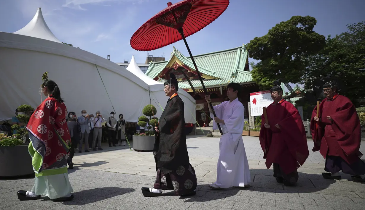 Pendeta Shinto mengadakan upacara upacara untuk festival dua tahunan yang disebut "Kanda Matsuri" di kuil Kanda di Tokyo (18/5/2022). Festival yang diadakan untuk kebahagiaan umat paroki kuil dan keselamatan Jepang ini pernah didukung oleh Keshogunan Tokugawa pada abad ke-17. (AP Photo/Eugene Hoshiko)