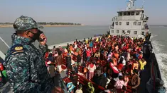 Pengungsi Rohingya duduk di kapal Angkatan Laut Bangladesh saat mereka dipindahkan ke pulau rawan banjir yang kontroversial, Bhashan Char di Teluk Benggala, di Chittagong (29/12/2020). Bangladesh mulai memindahkan pengungsi muslim Rohingya tahap kedua ke pulau terpencil tersebut. (AFP/Rehman Asad)