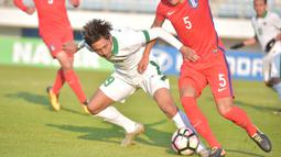 Gelandang Indonesia U-19, Muhammad Iqbal, berusaha melewati pemain Korea Selatan (Korsel) pada kualifikasi Piala Asia U-19 2018 di Stadion Paju, Sabtu (4/11/2017). Korsel menang 4-0 atas Indonesia. (AFP/Kim Doo-Ho)