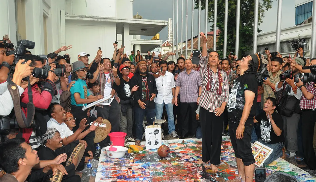 Mantan wali kota Solo itu terlihat melepas burung gereja yang sempat diberikan salah seorang seniman di depan Gedung Merdeka, Bandung, Rabu (11/6/14). (Liputan6.com/Herman Zakharia)