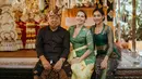 <p>Berpose bersama kedua orangtuanya, Laksmi Shari terlihat kembali mengenakan kebaya Bali dengan model yang lebih sederhana. Kebaya Bali kali ini berwarna hijau tua dengan bagian lengan yang transparan, dipadu kain bermotif sebagai bawahan, dan selendang hijau Army yang dililitkannya di pinggang. Foto: Instagram.</p>
