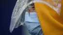 Penumpang memakai masker dan pelindung plastik darurat sebagai tindakan pencegahan terhadap virus corona COVID-19 setelah mendarat di bandara internasional Hong Kong (19/3/2020). Covid-19 yang menginfeksi lebih dari 200.000 orang terus menimbulkan kekhawatiran. (AFP/Anthony Wallace)