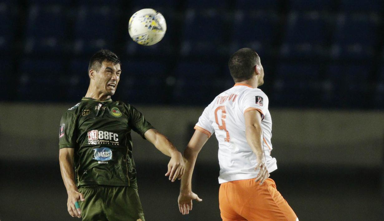 Bek Tira Persikabo, Khurshed Beknazarkov, duel udara dengan striker Perseru Serui, Turkovic Nedo, pada laga Piala Presiden 2019 di Stadion Si Jalak Harupat, Jawa Barat, Kamis (7/3). (Bola.com/M Iqbal Ichsan)