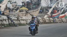 Sebagian warga menggunakan perahu dan sepeda motor sebagai transportasi menuju pelabuhan.  (merdeka.com/Iqbal S. Nugroho)