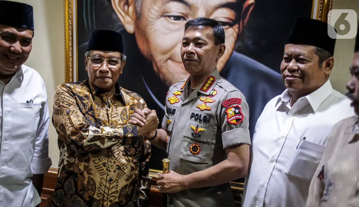 Kapolri Jenderal Pol Idham Azis menjabat tangan Ketum PBNU Said Aqil Siradj saat menyambangi Gedung PBNU di Jakarta, Selasa (12/11/2019). Kedatangan Idham merupakan tradisi pimpinan polri yang selalu menjalin silaturahmi dengan komponen masyarakat, salah satunya PBNU. (Liputan6.com/Faizal Fanani)