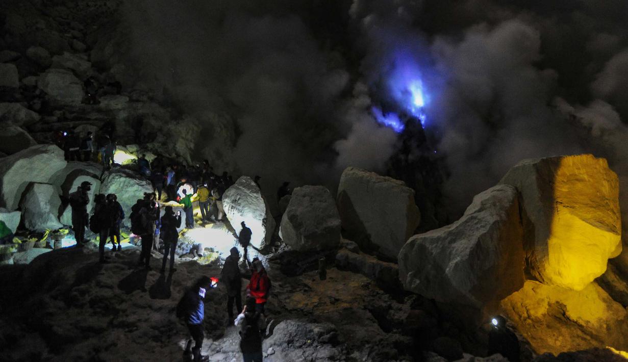 Kawah Ijen merupakan destinasi wisata unggulan di Jawa Timur yang berada di ketinggian sekitar 2.368 meter di atas permukaan laut. Kawasan ini dikenal memiliki salah satu kaldera terluas di Pulau Jawa. Secara administratif, Kawah Ijen terletak di perbatasan Kabupaten Banyuwangi dan Kabupaten Bondowoso, sehingga dapat diakses melalui dua jalur utama dari kedua wilayah tersebut. Tampak dalam foto, pengunjung menyaksikan blue fire di Kawah Gunung Ijen, Banyuwangi, Jawa Timur. (merdeka.com/Arie Basuki)