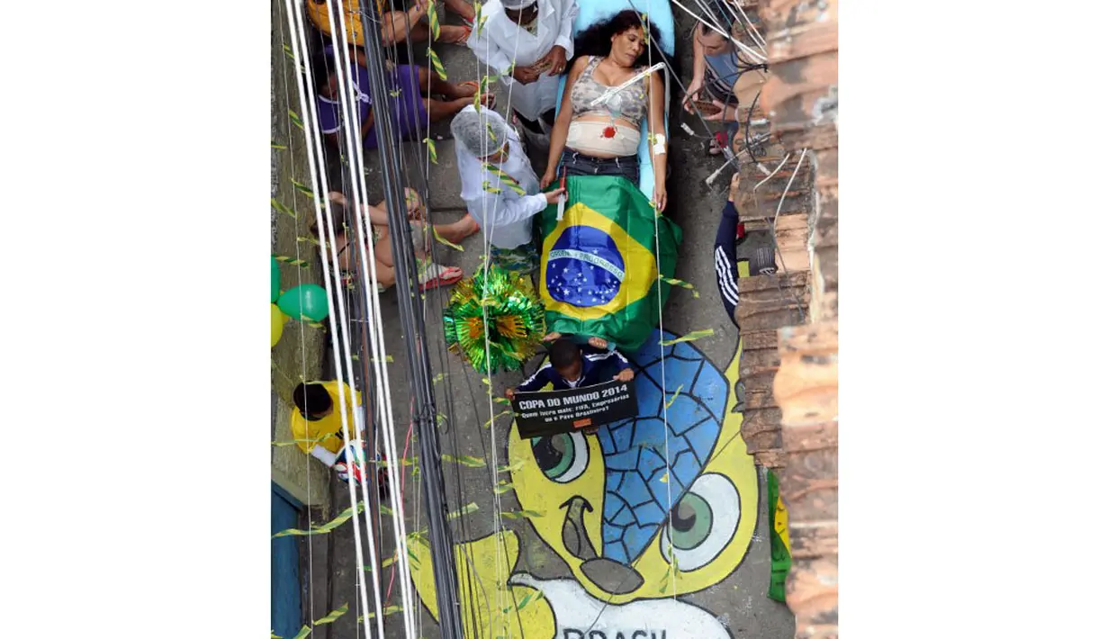 Di kawasan kumuh Jacarezinho, Rio de Janeiro, Brasil (10/5/2014), beberapa anggota LSM Rio de Paz melakukan aksi protes terhadap sistem perawatan kesehatan masyarakat jelang pelaksanaan Piala Dunia. (AFP PHOTO/Tasso Marcelo)