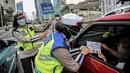 Polisi melakukan sosialisasi larangan mudik kepada pengguna jalan di kawasan Bundaran HI, Jakarta, Rabu (6/5/2020). Sosialisasi tersebut dilakukan demi memutus mata rantai penyebaran virus corona COVID-19 dari satu wilayah ke wilayah lain. (Liputan6.com/Faizal Fanani)