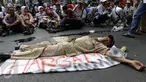 Seorang guru terlihat tidur di tengah jalan karena lelah usai melakukan unjuk rasa di depan Gedung DPR/MPR, Jakarta, Selasa (15/9/2015). Ribuan guru honorer melakukan aksi demo menuntut perubahan status honorer K2 menjadi PNS. (Liputan6.com/Yoppy Renato)