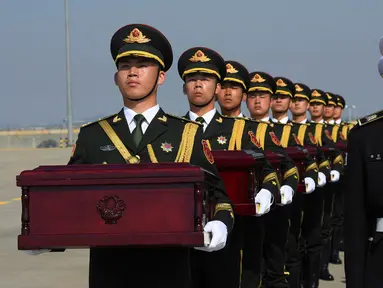Tentara membawa peti mati berisi sisa-sisa tentara China yang menjadi korban dalam Perang Korea di Bandara Internasional Incheon, Seoul, Korea Selatan, Rabu (3/4). Sebanyak 10 tentara China yang tewas dalam Perang Korea 1950-53 dipulangkan dari Korea Selatan. (Jung Yeon-je/Pool Photo via AP)