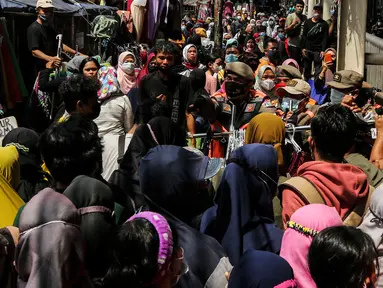 Aparat gabungan melakukan penertiban kepada pedagang yang berjualan di trotoar di kawasan Tanah Abang, Jakarta, Minggu (2/5/2021). Selain merazia barang dagangan pedagang, aparat gabungan juga menegur warga yang tidak menerapkan protokol kesehatan. (Liputan6.com/Johan Tallo)