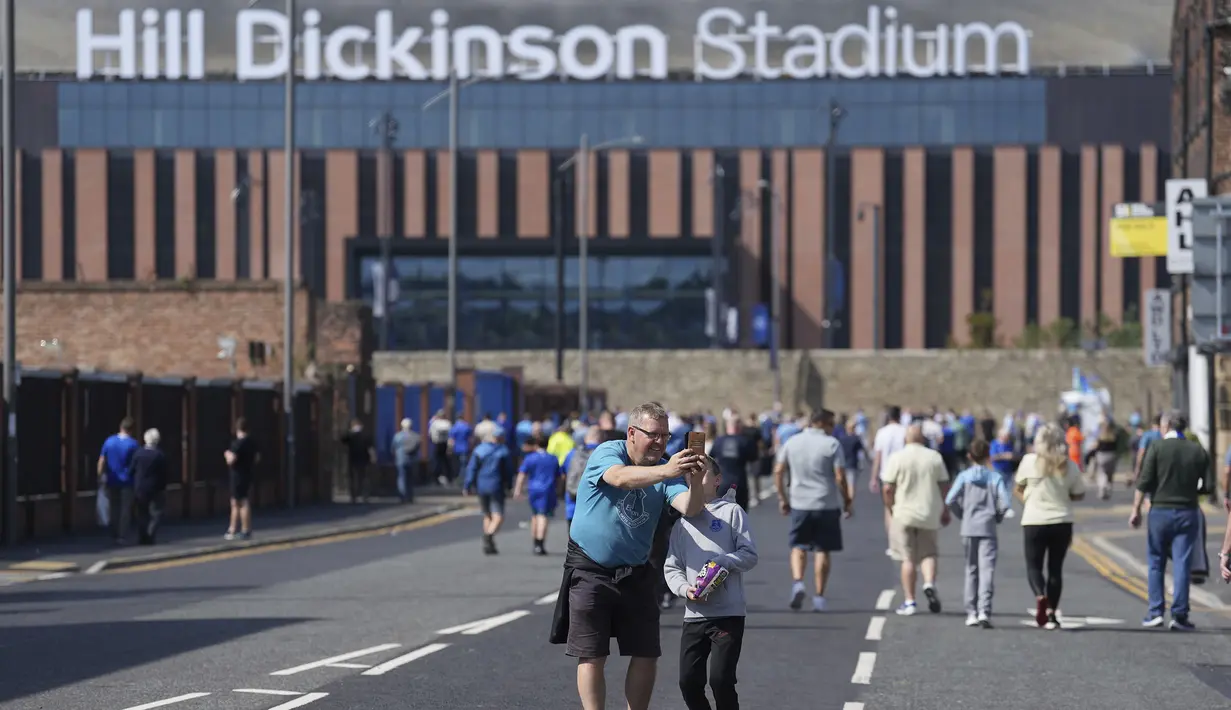 Seorang anak dan ayahnya melakukan swafoto dengan latar belakang Stadion Hill Dickinson menjelang laga Liga Inggris antara Everton melawan Brighton pada Minggu (24/08/2025) waktu setempat. (AP Photo/Jon Super)