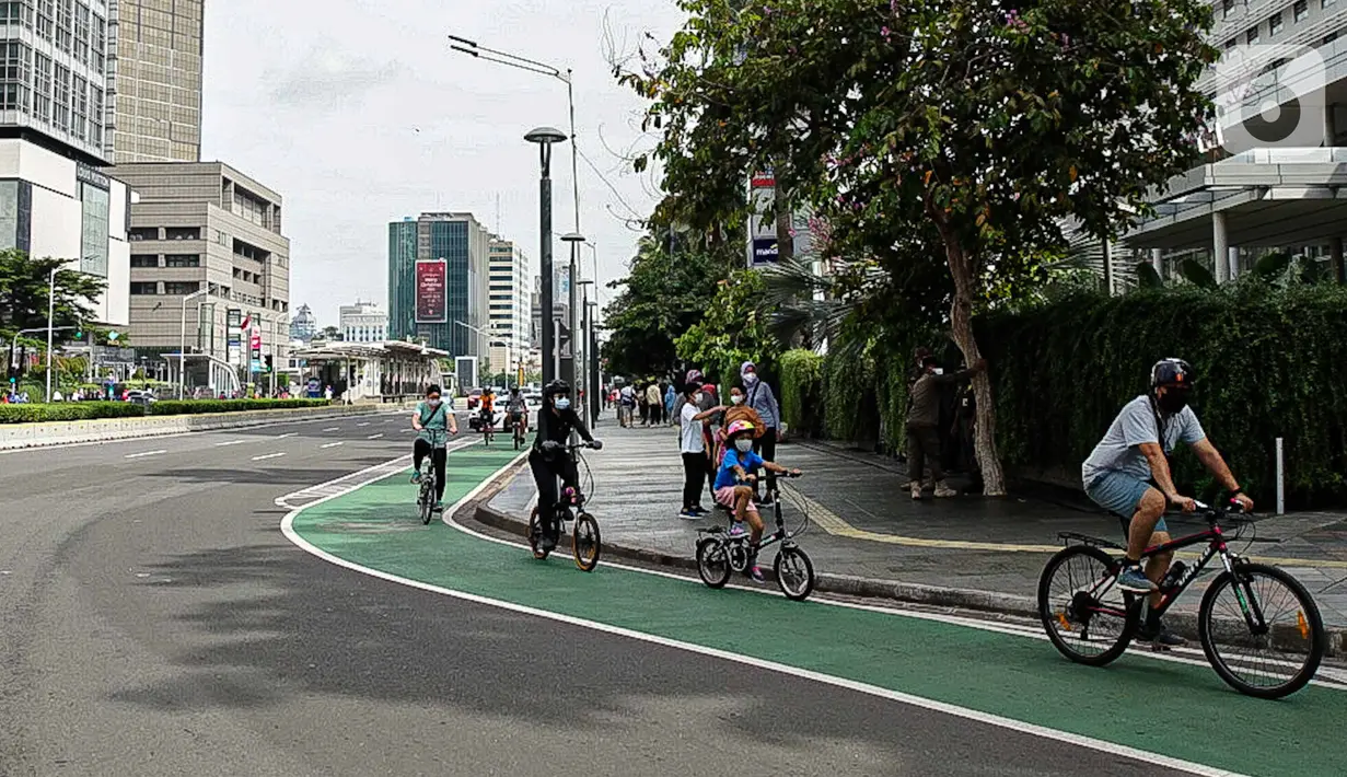 Sejumlah warga bersepeda di Bundaran HI, Jakarta, Minggu (2/1/2022). Meski hari bebas kendaraan bermotor atau car free day (CFD) ditiadakan, warga masih banyak yang beraktivitas di kawasan Sudirman-Thamrin. (Liputan6.com/Faizal Fanani)