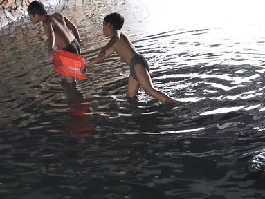 Anak-anak bermain sambil mencari ikan di Kali Pancoran, Jakarta, Jumat (14/9). Meski air kali yang keruh dan kotor dapat menyebabkan gangguan kesehatan, tidak menyurutkan niat anak-anak tersebut untuk tetap bermain. (Liputan6.com/Immanuel Antonius)
