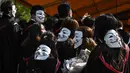 Mahasiswa mengenakan topeng Guy Fawkes selama aksi protes pada upacara kelulusan mereka di Chinese University of Hong Kong, Hong Kong, Kamis (7/11/2019). Sekitar seribu mahasiswa mengabaikan larangan mengenakan topeng yang dikeluarkan pemerintah pada Oktober 2019. (Philip FONG / AFP)