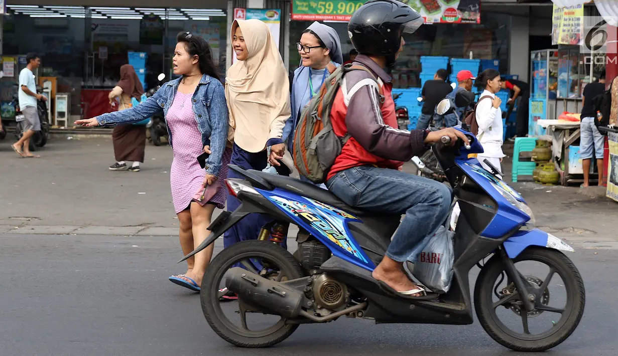 Senyum biarawati saat bergandeng tangan dengan wanita berkerudung ketika menyeberangi jalan di Lenteng Agung, Jakarta, Rabu (18/4). Keharmonisan keduanya dapat menjadi contoh bagi masyarakat dalam menjaga kedamaian. (Liputan6.com/Immanuel Antonius)