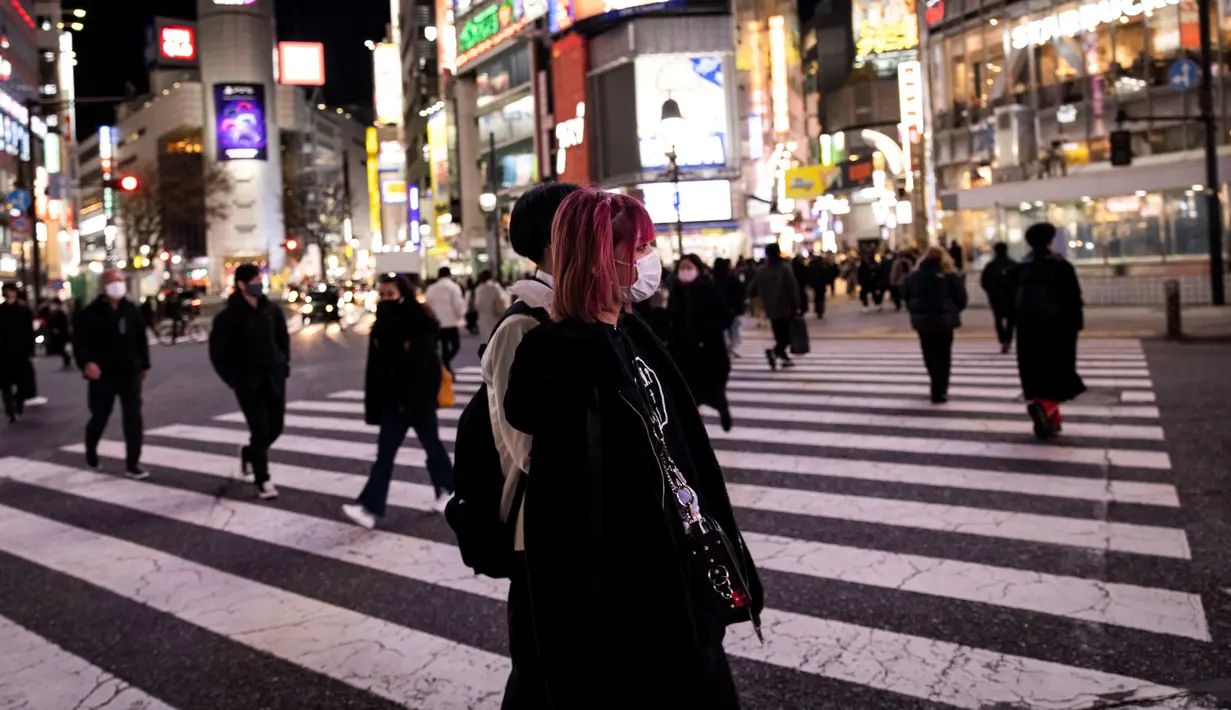 <p>Orang-orang yang memakai masker berjalan di distrik Shibuya di Tokyo (19/1/2022). Pemerintah Jepang menyetujui pembatasan virus corona baru di sebagian besar negara, termasuk ibu kota untuk memerangi rekor infeksi yang dipicu oleh varian Omicron. (AFP/Behrouz Mehri)</p>