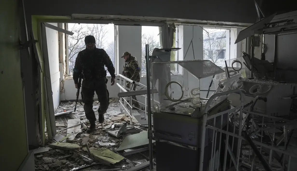 Prajurit Ukraina bekerja di dalam rumah sakit bersalin yang rusak akibat serangan udara di Mariupol, Ukraina (9/2/2022). Serangan Rusia telah merusak parah sebuah rumah sakit bersalin di kota pelabuhan Mariupol yang terkepung, kata pejabat Ukraina. (AP Photo/Evgeniy Maloletka)