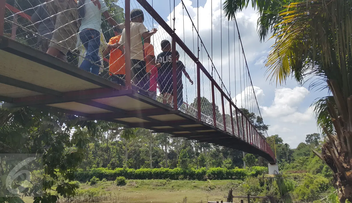 Warga mencoba jembatan baru di Desa Pintas Tuo, Kecamatan Muara Tabir, Jambi, (7/8). Selama ini warga terpaksa memutar sejauh 17 kilometer untuk menuju desa terdekat. Namun, mereka saat ini bisa lebih menghemat waktu. (Liputan6.com/dok SCTV)