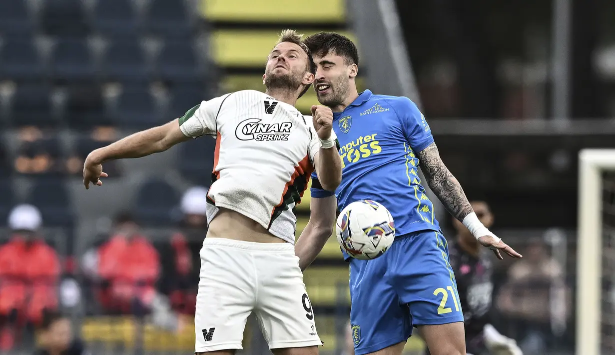 Pemain Venezia, Christian Gytkjaer (kiri) berebut bola dengan pemain Empoli, Mattia Viti dalam laga lanjutan Liga Italia 2024/2025 di Carlo Castellani Stadium, Empoli, Italia, Minggu (20/04/2025) waktu setempat. (AP Photo/LaPresse)
