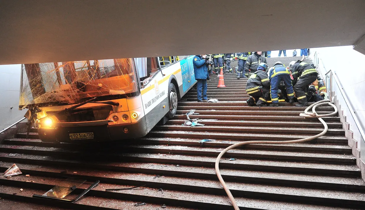 Petugas penyelamat di lokasi sebuah bus yang menorobos underpass khusus pejalan kaki di Moskow, Rusia, Senin (25/12). Kepolisian Moskow menyebutkan kejadian ini bukanlah sebuah serangan teroris, melainkan pengemudi hilang kendali. (AP/Ivan Sekretarev)