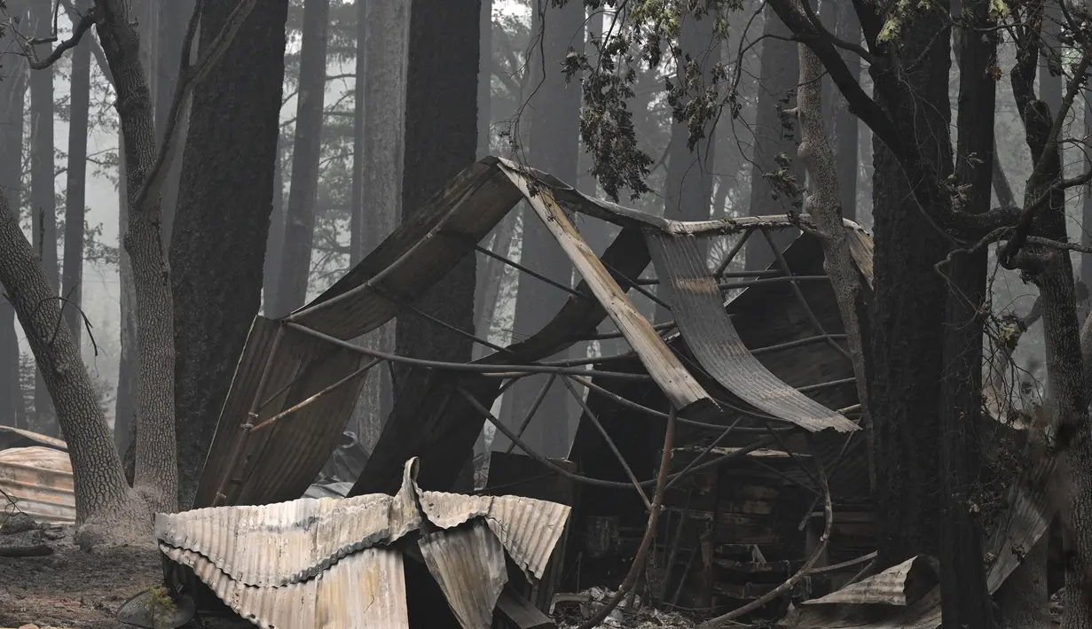 Rumah dan barang-barang pribadi terbakar dalam Kebakaran Dixie di daerah Air Terjun India di Plumas County, California (26/7/2021). Kebakaran tersebut berada di daerah terpencil dengan akses terbatas yang menghambat upaya petugas pemadam kebakaran saat bergerak ke timur. (AFP/Robyn Beck)