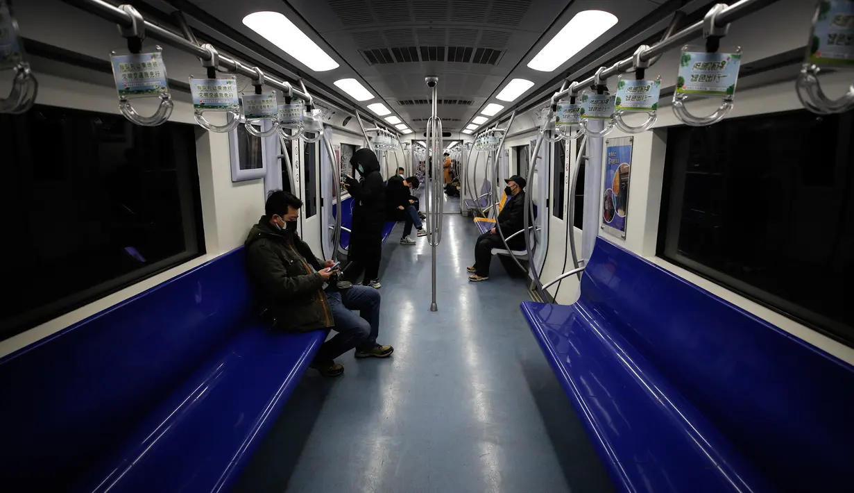 Komuter naik kereta bawah tanah di Beijing, China, Senin (17/2/2020). Tak seperti pada jam-jam sibuk di hari biasa, wabah virus corona atau COVID-19 membuat kereta dan transportasi publik lainnya di Beijing menjadi sepi. (AP Photo/Andy Wong)