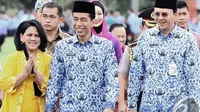 Iriana, Jokowi dan Ahok berjalan bersama saat menghadiri Upacara HUT Korps Pegawai Republik Indonesia (Korpri) ke-43 di halaman Monumen Nasional (Monas), Jakarta, Senin (1/12/2014). (Liputan6.com/Faizal Fanani)