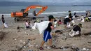 Ratusan orang, termasuk wisatawan asing, ikut dalam aksi bersih pantai massal di pesisir pantai Kedonganan, Badung, Bali, Sabtu 4 Januari 2025. (SONNY TUMBELAKA/AFP)