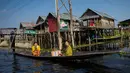 Masyarakat melewati rumah-rumah panggung menggunakan perahu di kampung terapung Danau Inle, Negara Bagian Shan, Myanmar, Senin (18/2). Seluruh kehidupan warga praktis berhubungan dengan perairan Danau Inle. (Ye Aung THU/AFP)