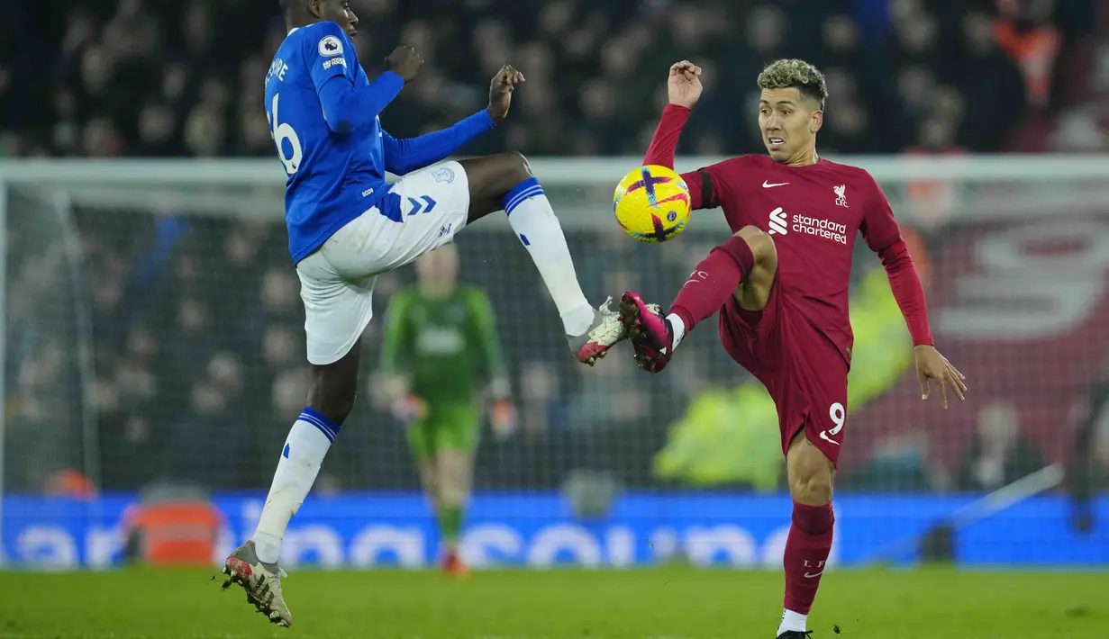Penyerang Liverpool, Roberto Firmino berebut bola dengan pemain Everton, Abdoulaye Doucoure selama pertandingan lanjutan Liga Inggris di stadion Anfield di Liverpool, Inggris, Selasa (14/2/2023). Everton ada di urutan ke-18 atau zona degradasi dengan 18 poin dari 22 pertandingan. (AP Photo/Jon Super)
