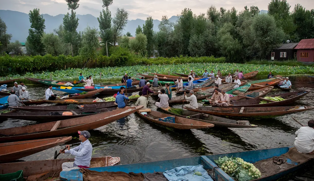 Para pria Kashmir menjual produk mereka di pasar sayur terapung di Danau Dal di Srinagar, Kashmir yang dikuasai India pada 26 Juli 2020. Sayuran yang diperdagangkan di pasar terapung ini disuplai ke Srinagar dan banyak kota di lembah Kashmir. (AP Photo/Dar Yasin)