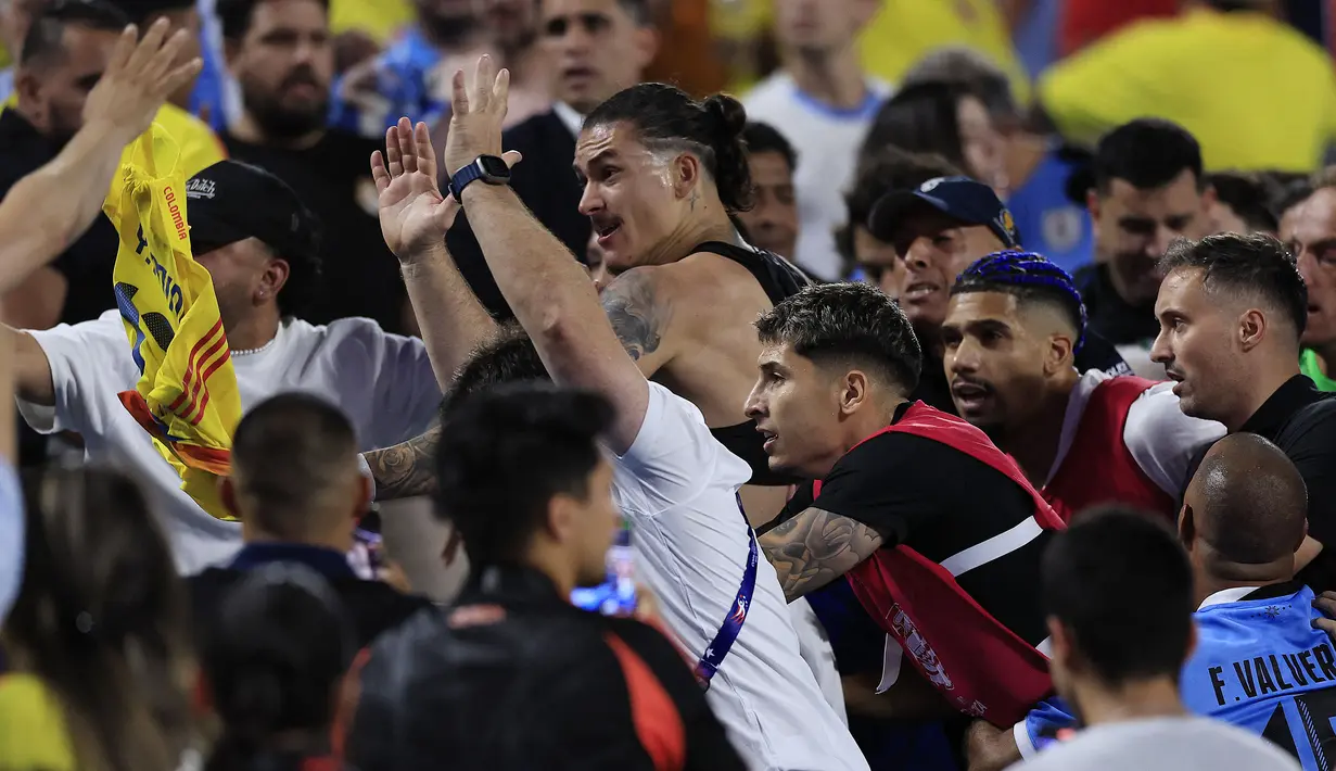 Striker Timnas Uruguay, Darwin Nunez (tengah) bersama rekan setim berusaha menghampiri suporter lawan di atas tribun penonton usai berakhirnya laga semifinal Copa America 2024 di Bank of America Stadium, Charlotte, Amerika Serikat, Kamis (11/7/2024) pagi WIB. (AFP/Getty Images/Buda Mendes)