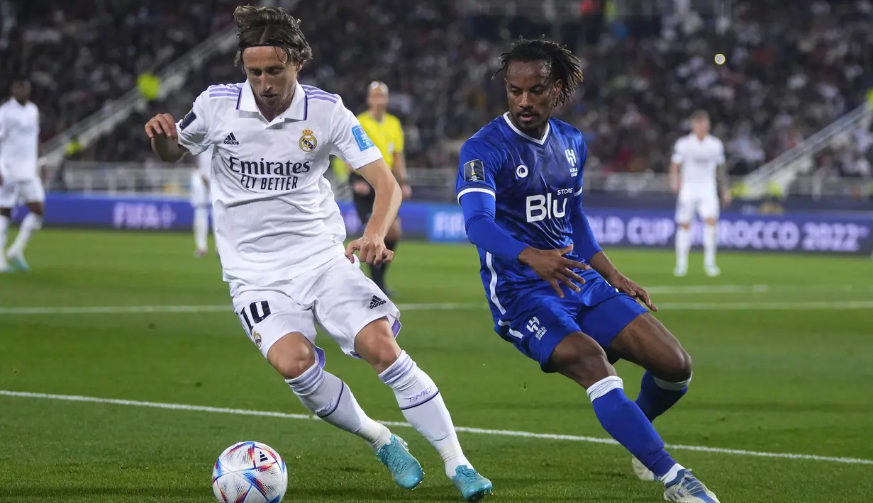 Gelandang Real Madrid Luka Modric berebut bola dengan gelandang Al Hilal Andre Carrillo dalam partai final Piala Dunia Antarklub 2022 di Prince Moulay Abdellah Stadium, Rabat, Minggu (12/2/2023) dini hari WIB. Berkat hasil ini, Real Madrid pun berhak menjadi juara Piala Dunia Antarklub untuk kelima kalinya. (AP Photo/Manu Fernandez)