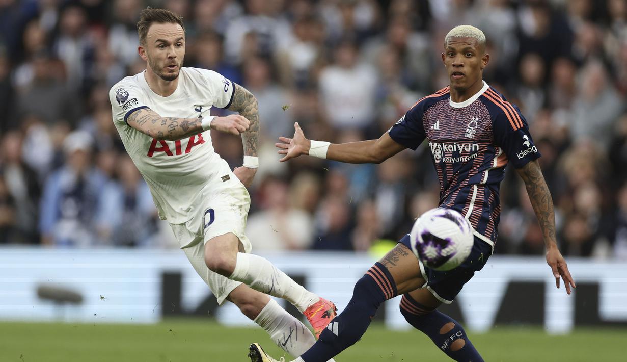 Gelandang Tottenham Hotspur, James Maddison (kiri) melepaskan tendangan di depan gelandang Nottingham Forest, Danilo pada laga pekan ke-32 Premier League 2023/2024 di Tottenham Hotspur Stadium, London, Minggu (7/4/2024) malam. (AP Photo/Ian Walton)