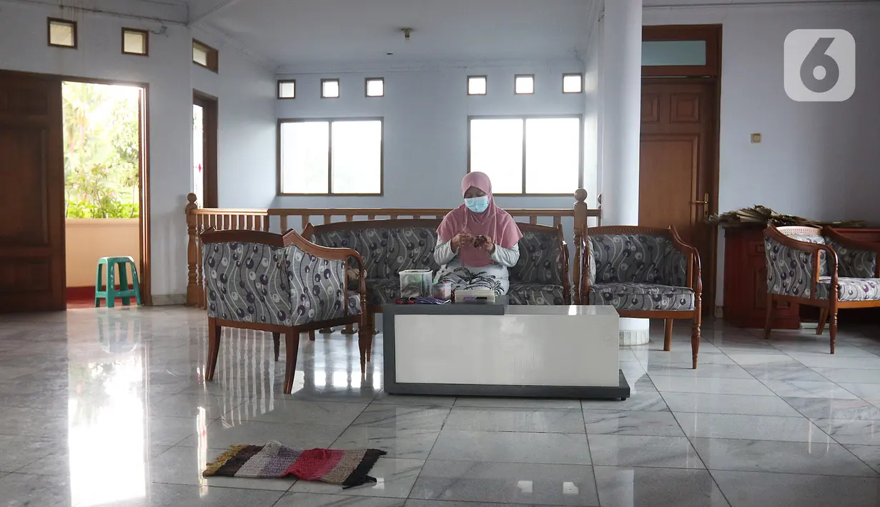 NY yang sedang melakukan isolasi mandiri karena terjangkit COVID-19 menjahit di kediamannya, Rabu (10/2/2021). Terkonfirmasi sebagai OTG tak membuat NY berkecil hati. (Liputan6.com/Herman Zakharia)