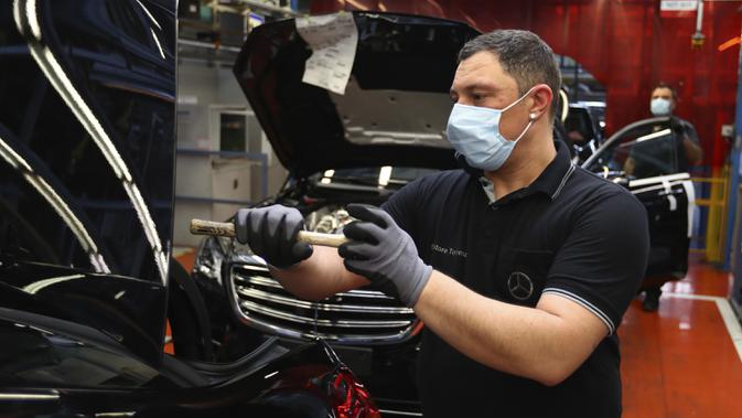 Pekerja merakit mobil Mercedes-Benz S-class di pabrik Mercedes, Sindelfingen, Jerman, Kamis (30/4/2020). Mulai 27 April 2020, Mercedes-Benz kembali membuka jalur produksi yang sebelumnya ditutup karena pandemi virus corona COVID-19. (AP Photo/Matthias Schrader)