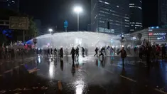 Polisi menembakkan meriam air untuk membubarkan demonstran yang memblokir jalan selama protes menentang rencana pemerintah Perdana Menteri Benjamin Netanyahu untuk melakukan reformasi peradilan di Tel Aviv, Israel, Senin (27/3/2023). (AP Photo/Oded Balilty)
